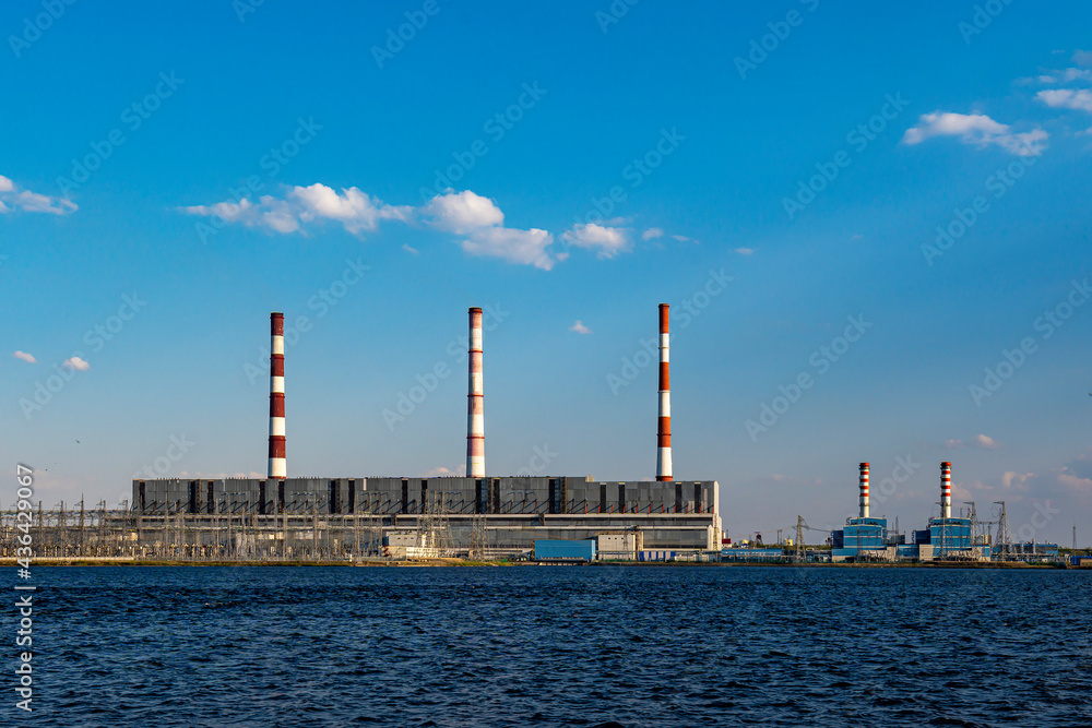 Hydroelectric power station operates and produces energy and electricity on shore of a reservoir in city