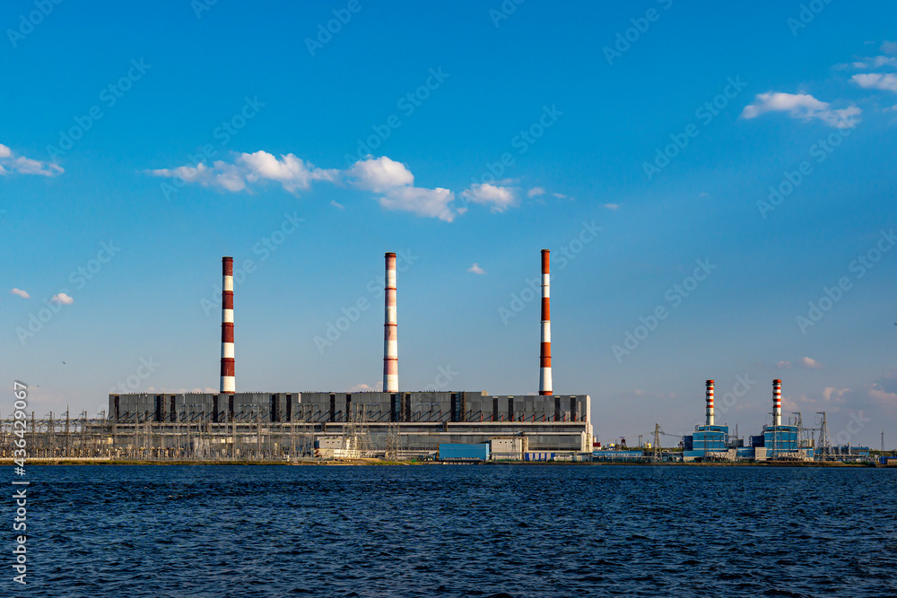 Hydroelectric power station operates and produces energy and electricity on shore of a reservoir in city Hydroelectric power station operates and produces energy and electricity on shore of a reservoir in city