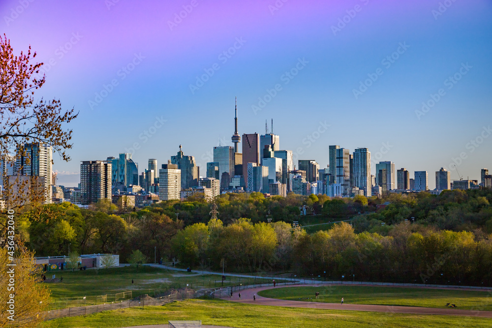 Obraz premium Toronto, Ontario, Canada. Downtown Toronto, cityscape skyline view Riverdale park east. People walking in the park, playing sports sitting on a picnic.