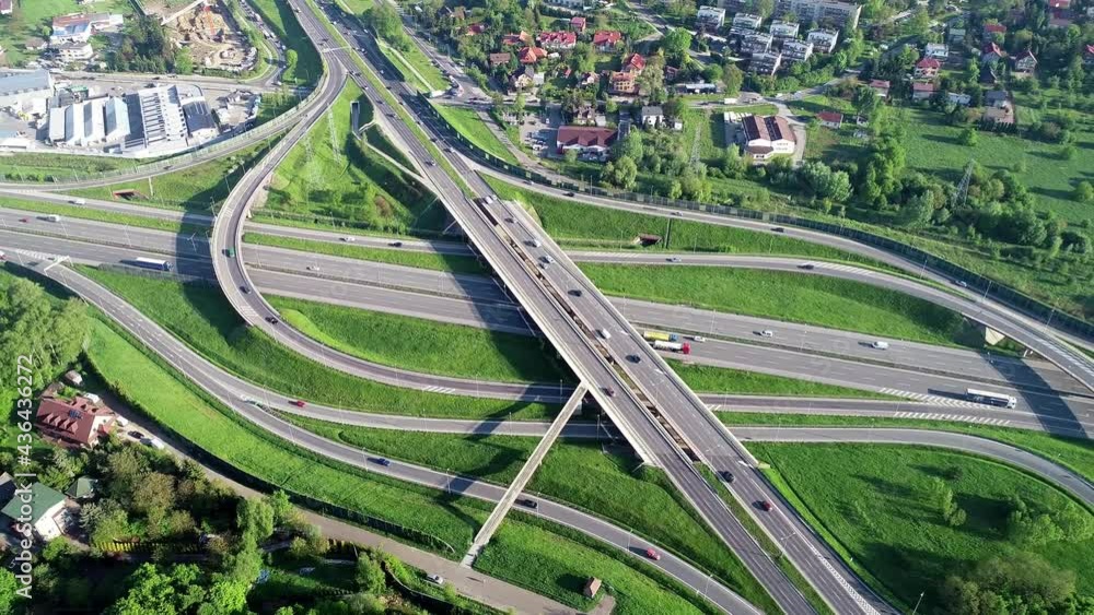 Motorway multilevel crossing. Spaghetti junction on A4 international highway, the part of orbital road around Krakow, Poland. Aerial 4K revealing video in spring Motorway multilevel crossing. Spaghetti junction on A4 international highway, the part of orbital road around Krakow, Poland. Aerial 4K revealing video in spring