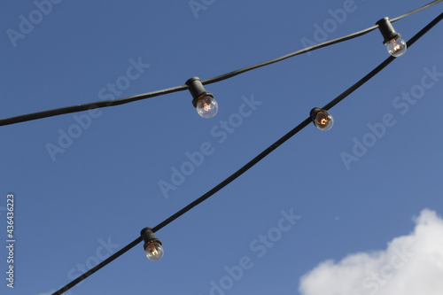 detail of row of light bulbs in blue sky