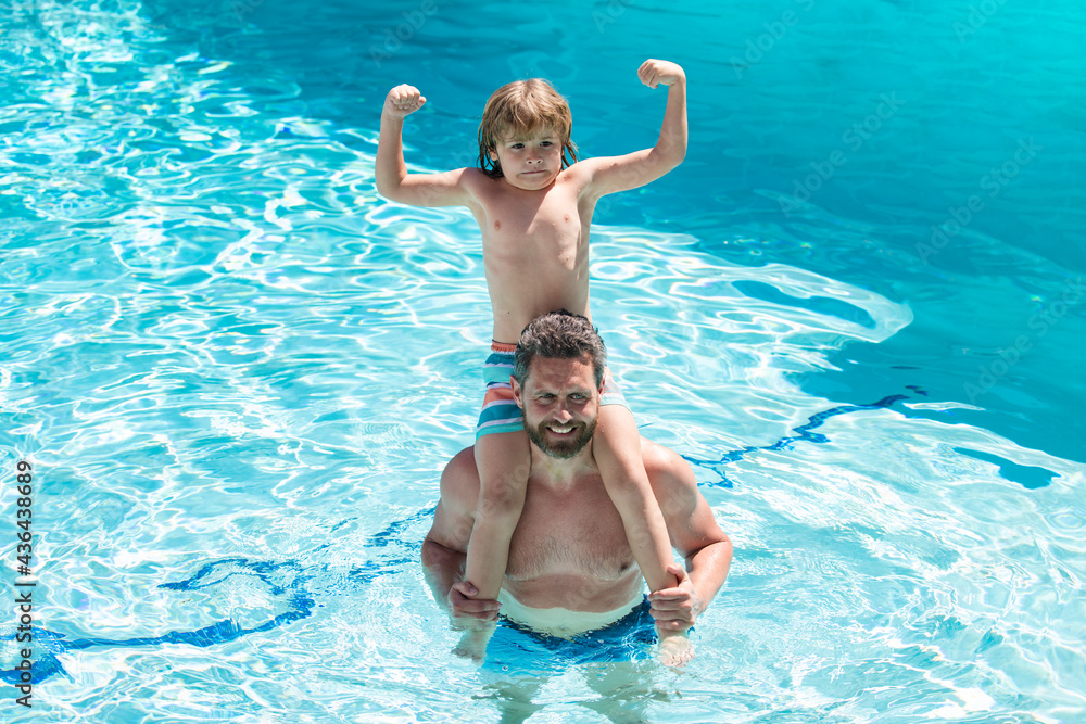 Dad and son in swimmingpool. Swimming lessons. Summer holidays. Fathers Day.