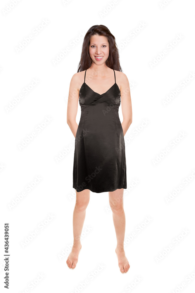 Happy young woman wearing an elegant black evening dress with her hands on her back, isolated in front of white studio background Happy young woman wearing an elegant black evening dress with her hands on her back, isolated in front of white studio background
