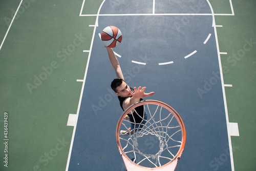 Basketball concept. Man jumping and making a slam dunk playing streetball, basketball. Urban authentic. © Volodymyr