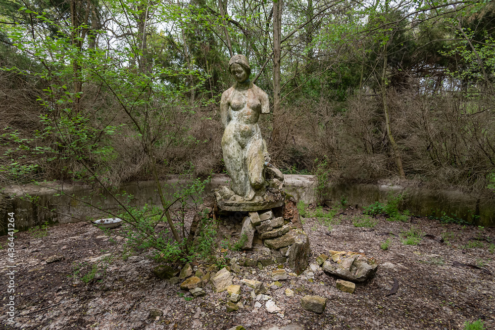 Becej, Serbia - May 01, 2021: The summer house of the noble family Gombos and a fountain in the shape of a bust of a young woman left to the ravages of time. Becej, Serbia - May 01, 2021: The summer house of the noble family Gombos and a fountain in the shape of a bust of a young woman left to the ravages of time.