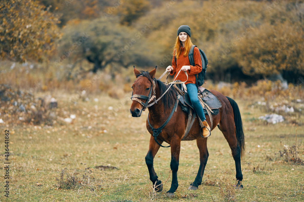 woman hiker rides a horse in a field mountains nature landscape woman hiker rides a horse in a field mountains nature landscape
