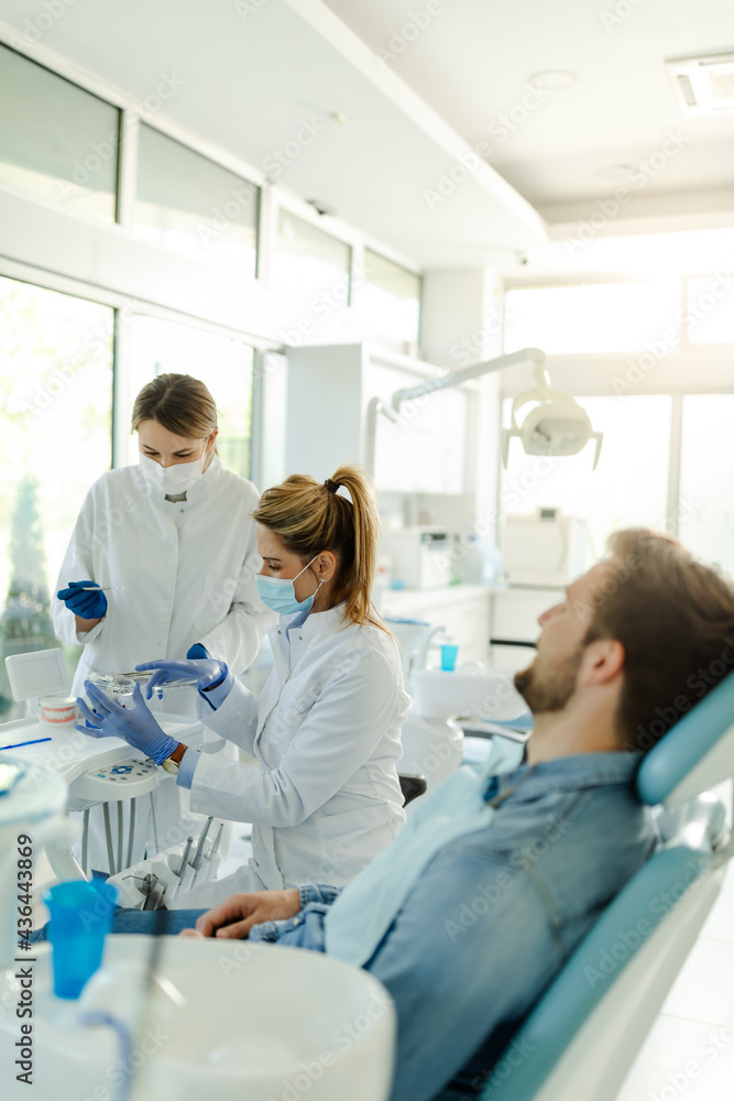 The female dentist and the assistant prepare the instruments for the dental examination. The female dentist and the assistant prepare the instruments for the dental examination.