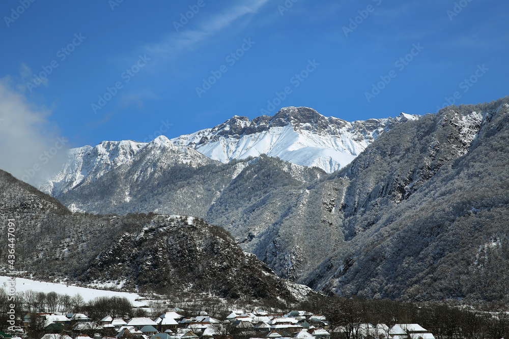 Mountain view of the village. The leaves of the trees fell on the mountain. It snowed in the mountains and in the village. Bash Dashagil village of Oguz region.Blue sky . It snowed in the village.