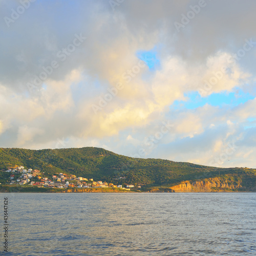 Rocky shores (cliffs, mountains) of Gibraltar at sunrise, a view from the sailing boat. Spain. Dramatic sky, soft sunlight. Travel destinations, national landmark, sightseeing, nature photo