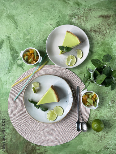 Composition with lemon cheesecake  green art background, top view, copy space.