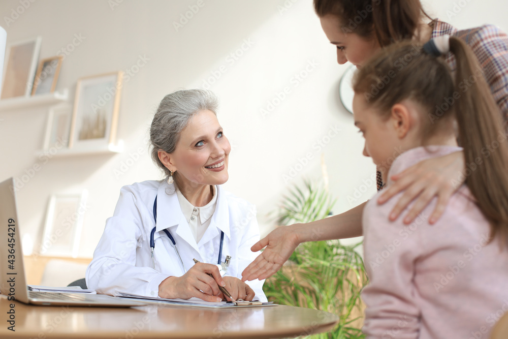 Mother and child in the doctor office meeting the pediatrician, they are sitting at desk in hospital. Mother and child in the doctor office meeting the pediatrician, they are sitting at desk in hospital.