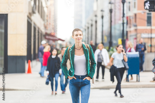 Confident young woman crossing the street in the city