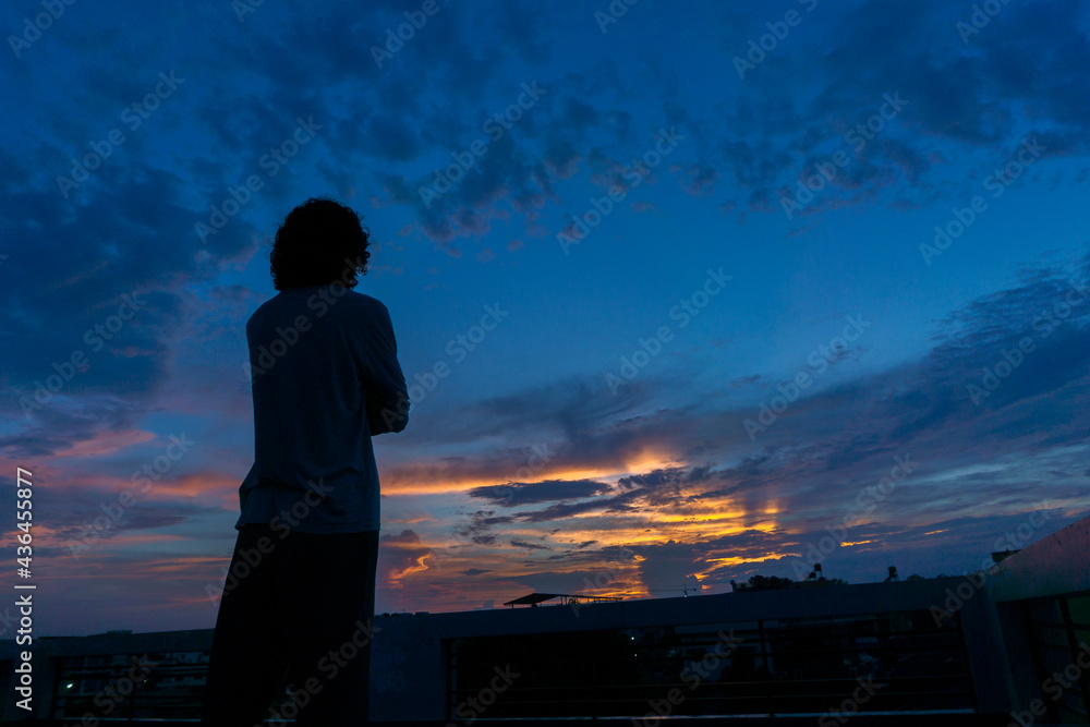 Fototapeta premium A person looking at the evening sky at dusk.