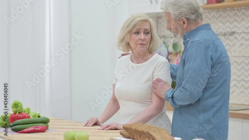 Senior Old Man Talking to Sad Senior Old Woman in Kictchen photo