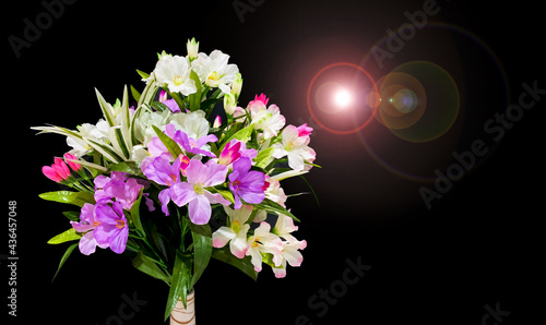 Arificial flower bouquet on vase with lens flare effect on black, handmade floral, photo