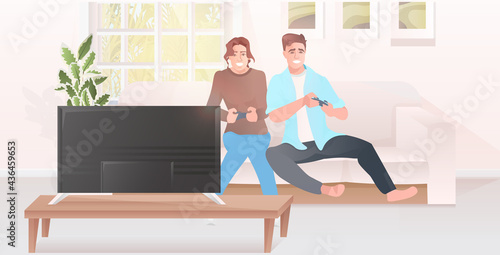 couple using joysticks game pad man woman playing video games on tv guy girl spending time together