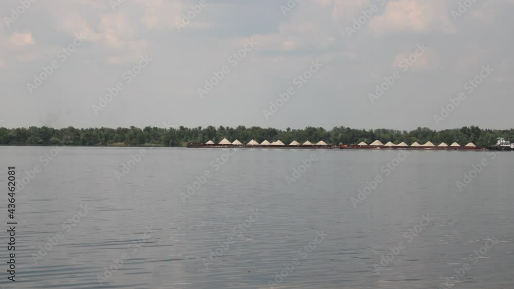 The tug pushes the barge along river. The tug pushes the barge along river.
