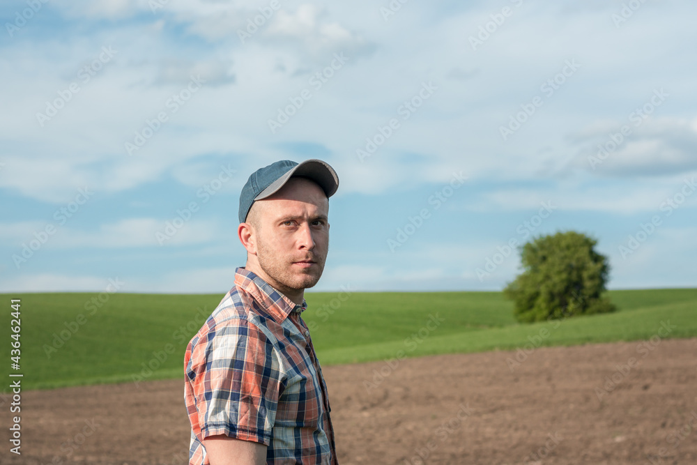 Portrait of a male agronomist who inspects wheat crops in an agricultural field. Farmer in a wheat field. Grain crop yield assessment Portrait of a male agronomist who inspects wheat crops in an agricultural field. Farmer in a wheat field. Grain crop yield assessment