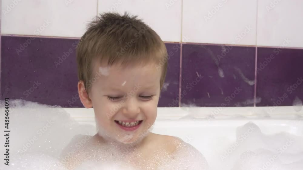 Close-up of a happy smiling little boy with a lot of foam in the bath.He claps his hands foam. Close-up of a happy smiling little boy with a lot of foam in the bath.He claps his hands foam.