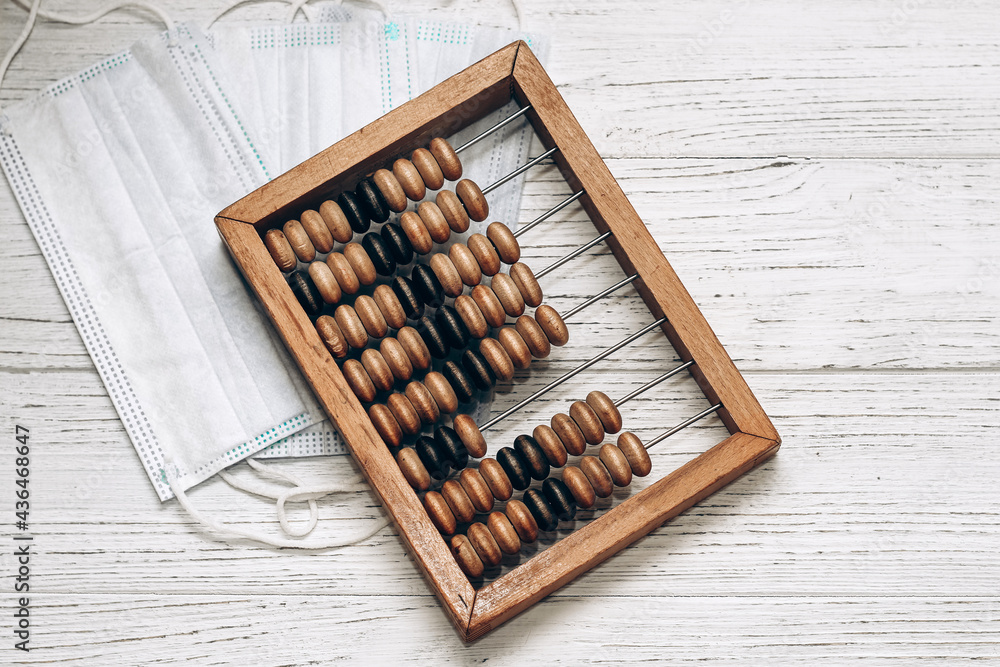 wooden abacus with medical masks on a white background. Treatment cost concept. wooden abacus with medical masks on a white background. Treatment cost concept.