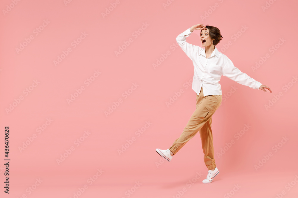 Full length side view fun young employee business woman corporate lawyer in classic formal white shirt work in office hold hand at forehead look far away distance isolated on pastel pink background.