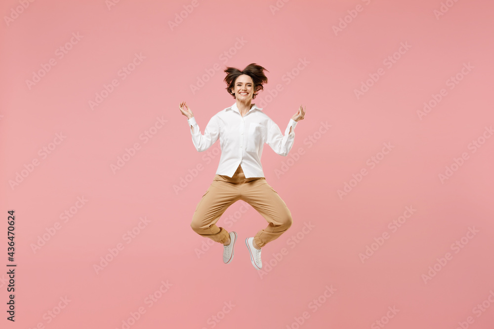Full length young employee business woman corporate lawyer in white shirt work in office hold spreading hands in yoga om aum gesture relax meditate try calm down isolated on pastel pink background. Full length young employee business woman corporate lawyer in white shirt work in office hold spreading hands in yoga om aum gesture relax meditate try calm down isolated on pastel pink background.