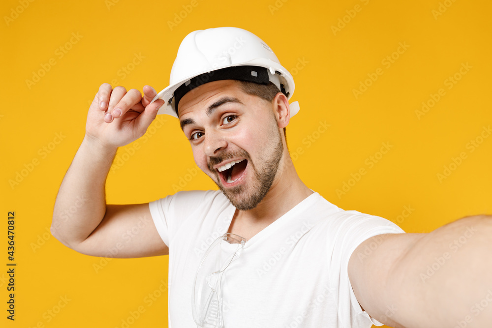 Close up young employee handyman man in protective helmet do selfie shot mobile phone tip hardhat isolated on yellow background Instruments accessories renovation apartment room Repair home concept