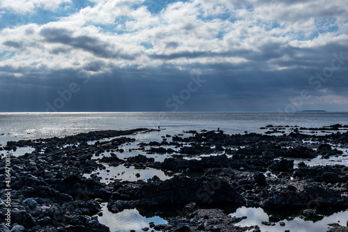 Jeju Island s sea where the sun shines through the clouds