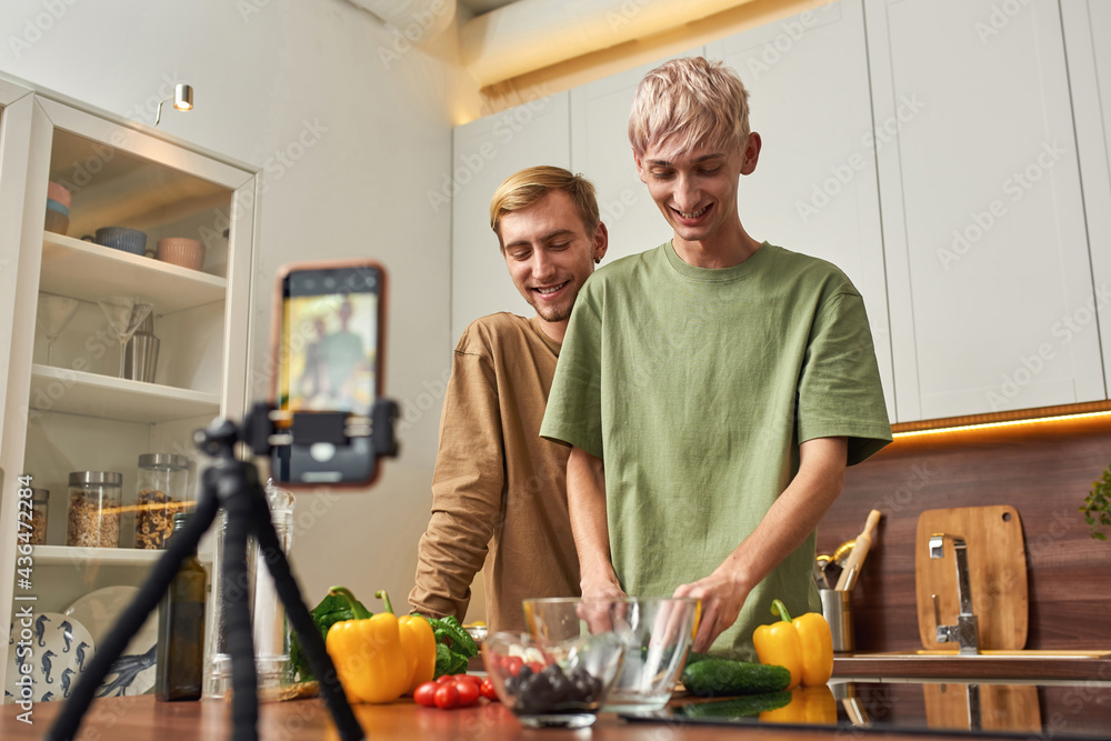 Happy homosexual male couple shooting vlog about cooking Happy homosexual male couple shooting vlog about cooking
