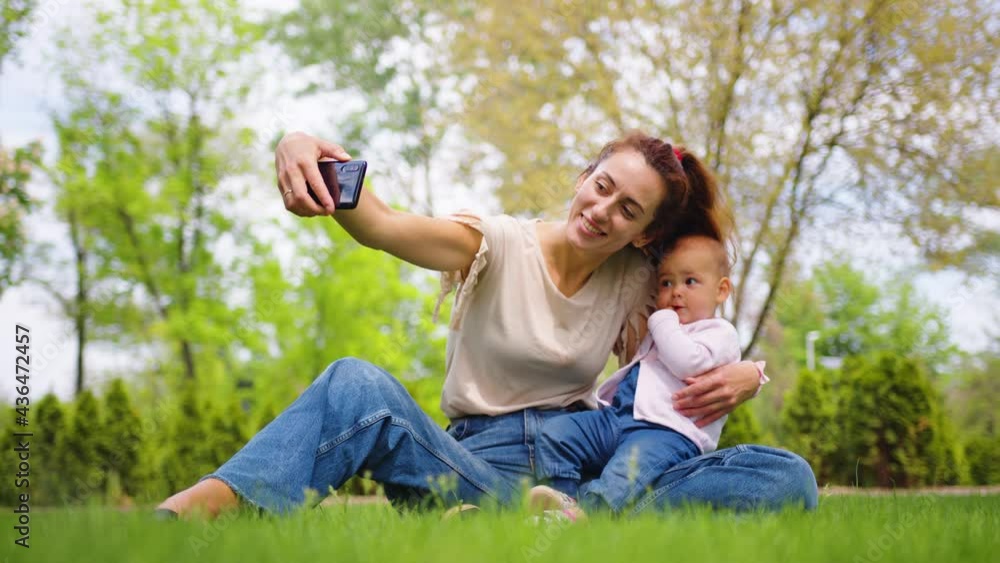 Close up of mother with baby daughter posing for cell phone selfies outdoor. Close up of mother with baby daughter posing for cell phone selfies outdoor.