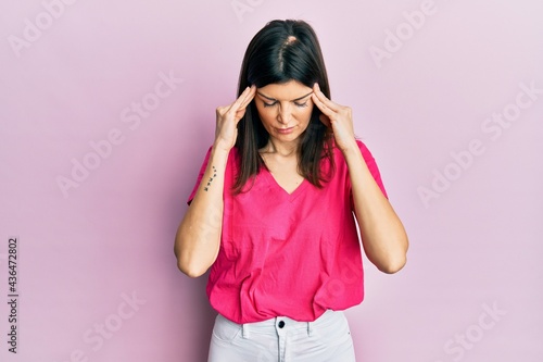 Young hispanic woman wearing casual clothes suffering from headache desperate and stressed because pain and migraine. hands on head. © Krakenimages.com