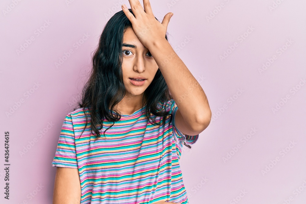 Hispanic teenager girl with dental braces wearing casual clothes surprised with hand on head for mistake, remember error. forgot, bad memory concept. Hispanic teenager girl with dental braces wearing casual clothes surprised with hand on head for mistake, remember error. forgot, bad memory concept.