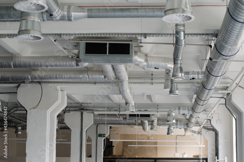 Air condition and hvac system installation under bareskin ceiling before interior finishing. System of industrial ventilating pipes. Air flow and ventilation system.