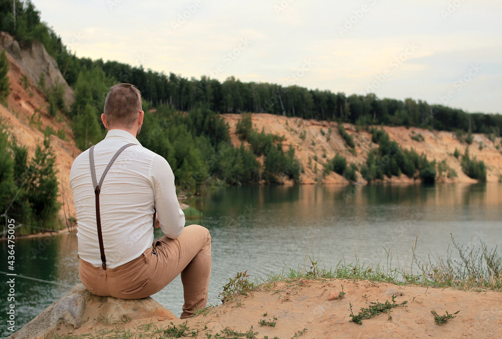 Fototapeta premium Person sitting on the shore