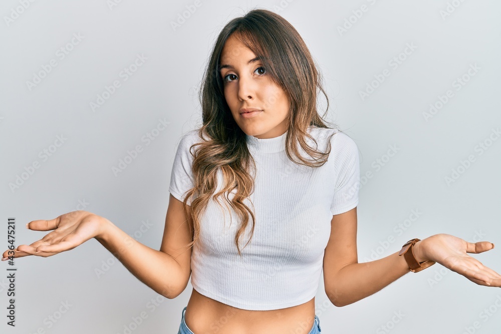Young brunette woman wearing casual white t shirt clueless and confused with open arms, no idea concept. Young brunette woman wearing casual white t shirt clueless and confused with open arms, no idea concept.