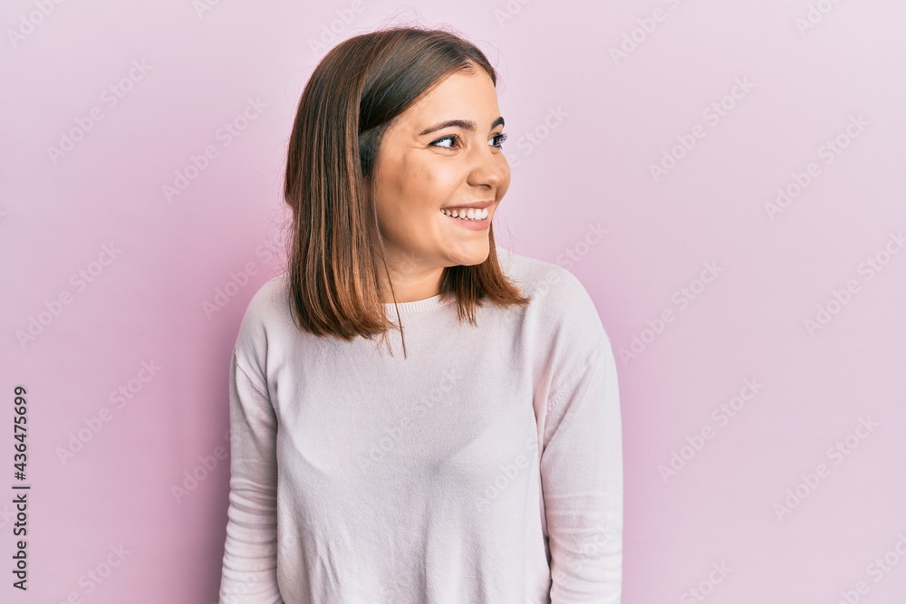 Fototapeta premium Young beautiful woman wearing casual clothes looking away to side with smile on face, natural expression. laughing confident.