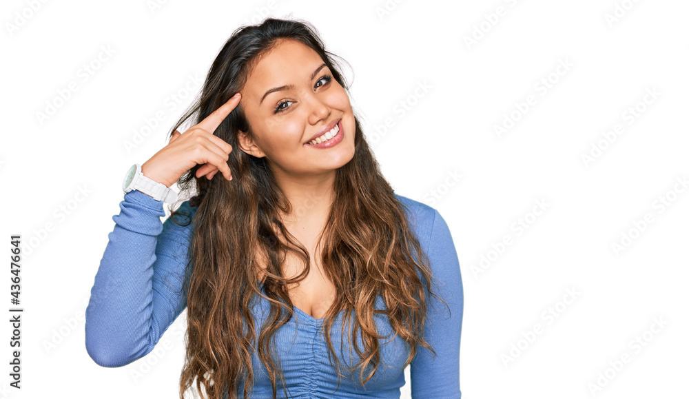 Young hispanic girl wearing casual clothes smiling pointing to head with one finger, great idea or thought, good memory Young hispanic girl wearing casual clothes smiling pointing to head with one finger, great idea or thought, good memory