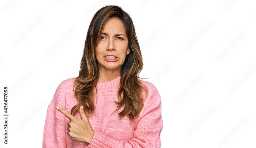 Young hispanic woman wearing casual clothes pointing aside worried and nervous with forefinger, concerned and surprised expression Young hispanic woman wearing casual clothes pointing aside worried and nervous with forefinger, concerned and surprised expression