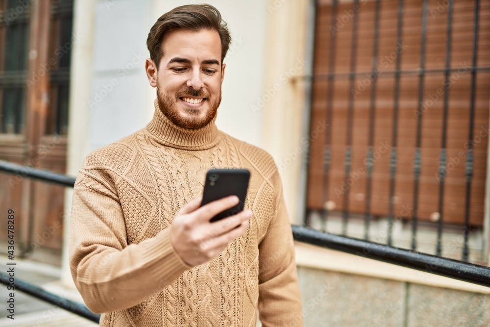 Young caucasian man smiling happy using smartphone at the city. Young caucasian man smiling happy using smartphone at the city.