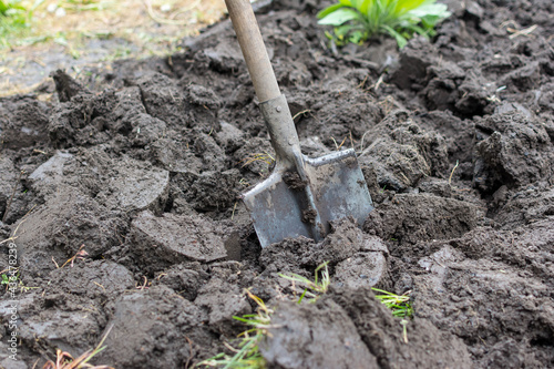shovel stuck in the ground, dug in the background field tools for working in the garden