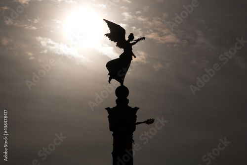 Silhouette of an ancient roman bronze angel statue on a pillar. Angels of peace. Vittoriano monument.