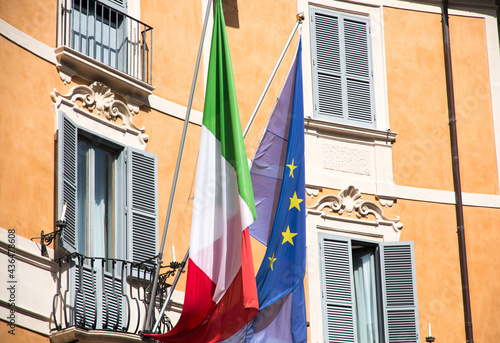 Canvas Print European flag and Italian flag hanging on a balcony in Italy during daytime