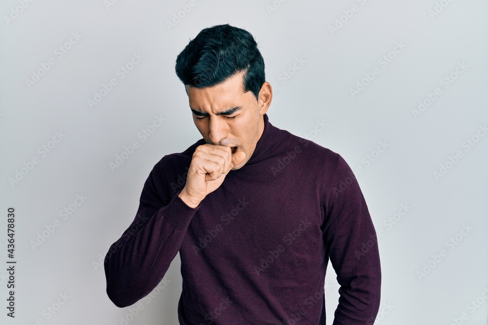 Handsome hispanic man wearing turtleneck sweater feeling unwell and coughing as symptom for cold or bronchitis. health care concept.
