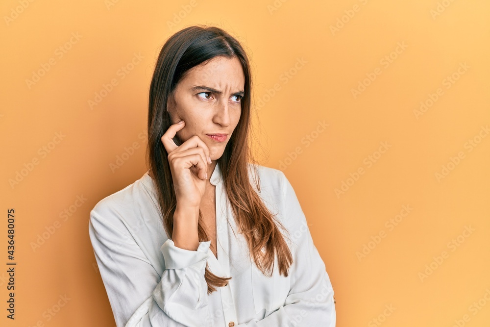 Young beautiful woman wearing casual clothes thinking concentrated about doubt with finger on chin and looking up wondering Young beautiful woman wearing casual clothes thinking concentrated about doubt with finger on chin and looking up wondering
