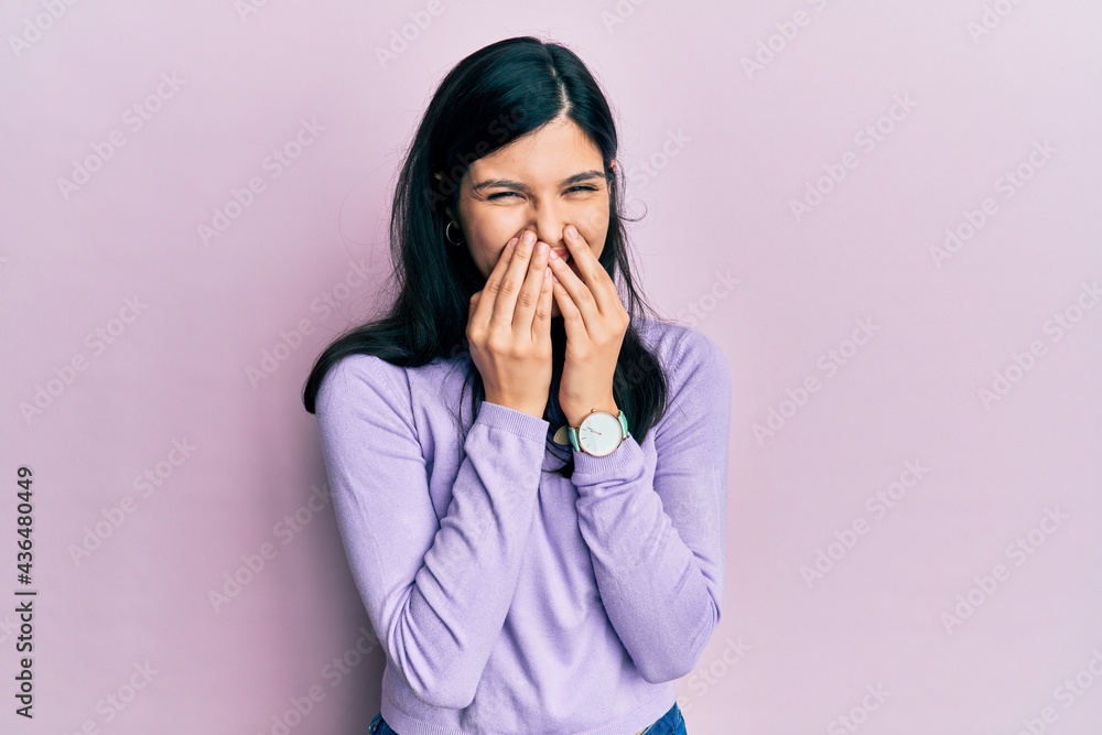 Young hispanic woman wearing casual clothes laughing and embarrassed giggle covering mouth with hands, gossip and scandal concept Young hispanic woman wearing casual clothes laughing and embarrassed giggle covering mouth with hands, gossip and scandal concept