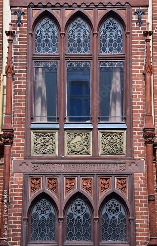 Ancient, red bricked facade with artful decorated window in Schwerin, Germany