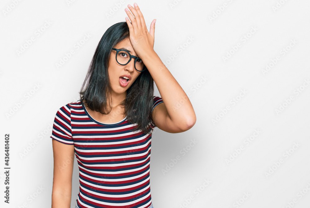 Beautiful asian young woman wearing casual clothes and glasses surprised with hand on head for mistake, remember error. forgot, bad memory concept. Beautiful asian young woman wearing casual clothes and glasses surprised with hand on head for mistake, remember error. forgot, bad memory concept.