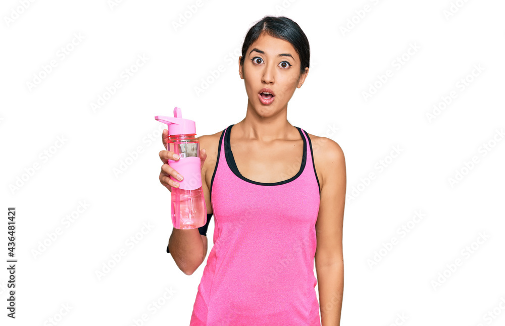 Beautiful asian young sport woman wearing sportswear drinking bottle of water scared and amazed with open mouth for surprise, disbelief face Beautiful asian young sport woman wearing sportswear drinking bottle of water scared and amazed with open mouth for surprise, disbelief face