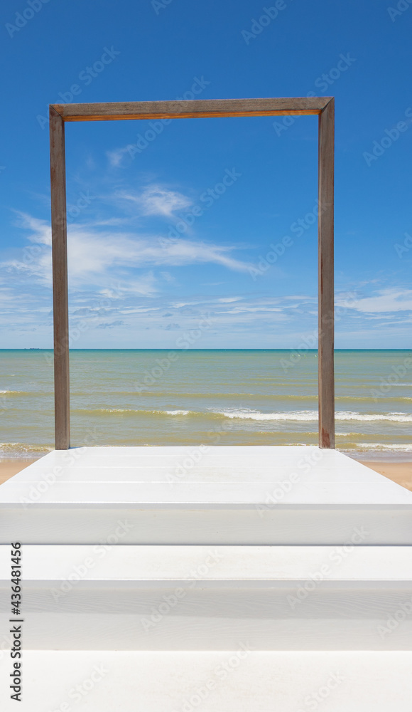 Fototapeta premium Ladder with steps to the wooden frame in front of clear and beautiful scenic view of blue sea and clear sky with horizon in tropical island shows art concept for path of success to heaven door.