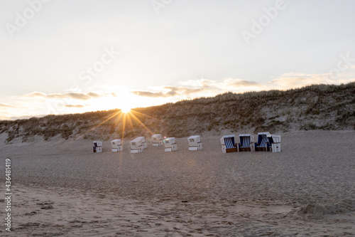Fototapeta Naklejka Na Ścianę i Meble -  Sunset on the beach of Westerland on Sylt. deserted beach chairs in the golden hour. 